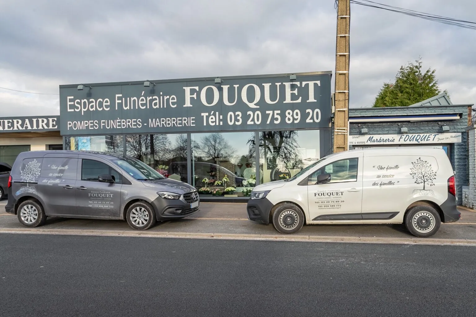 Devanture de l'Espace Funéraire Fouquet avec des véhicules de pompes funèbres stationnés