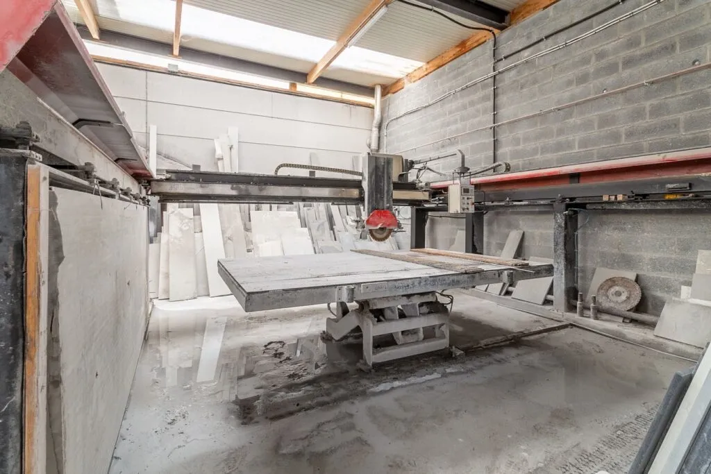 Atelier de marbrerie funéraire équipé d'une machine de découpe industrielle pour dalles de granit