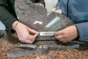 Personnalisation d'une plaque funéraire en granit en forme de papillon avec inscription du souvenir